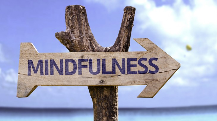 Mindfulness wooden sign with a beach on background